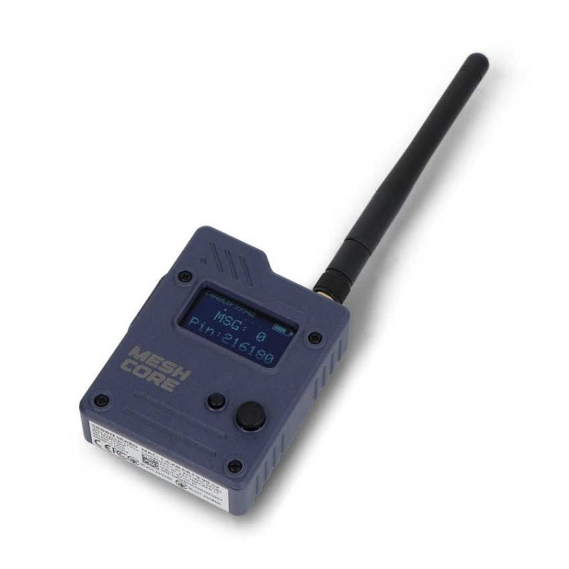 Bærbar MeshCore-node med antenne og OLED-skjerm i skrå vinkel
